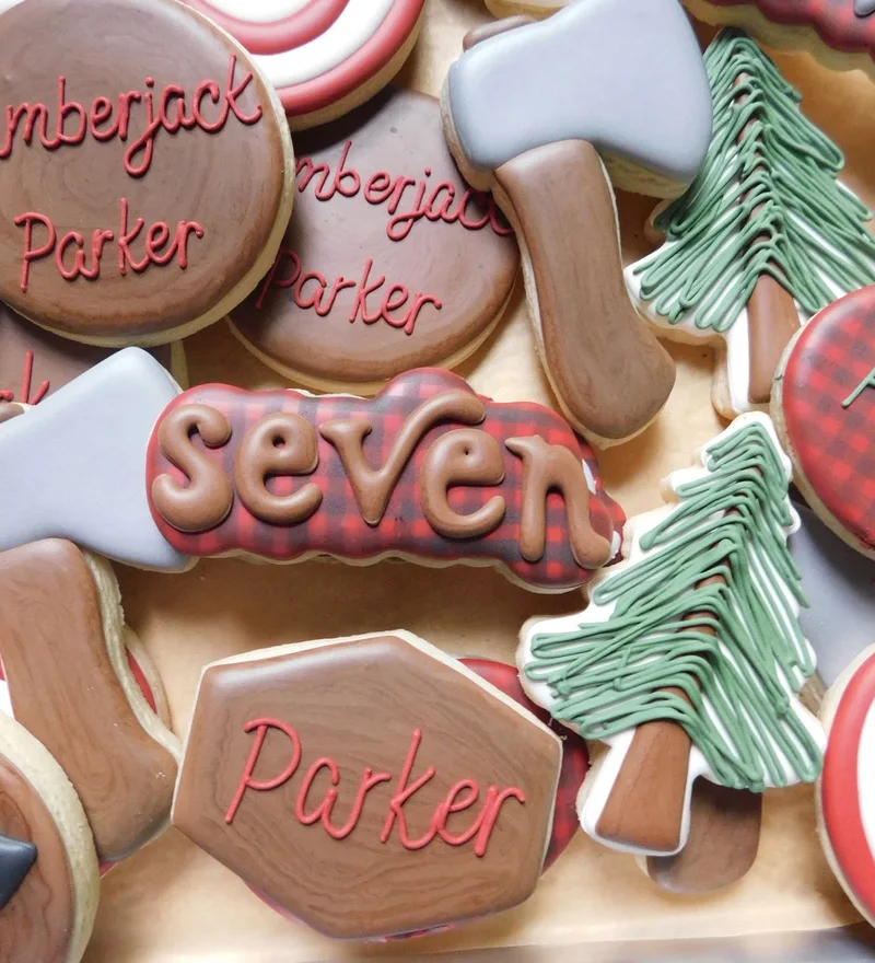Lumberjack-themed cookies with axes, plaid, and pine trees.