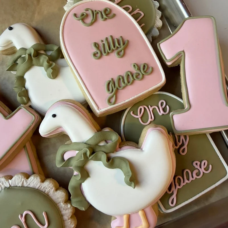 Goose and number one cookies in pink and green for a first birthday.