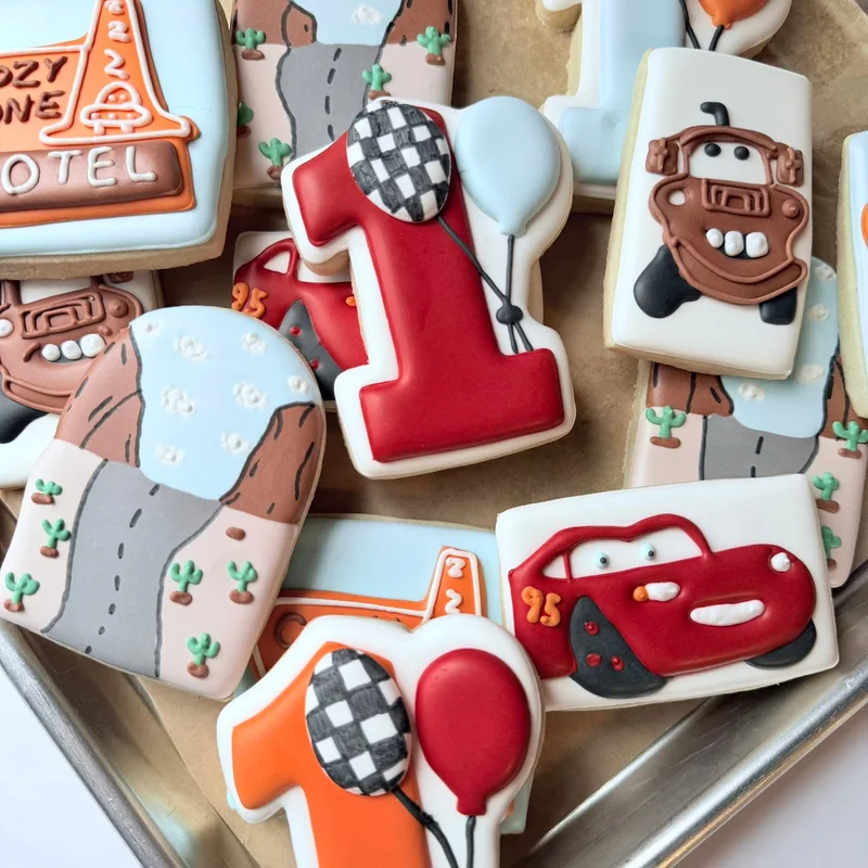 Cartoon race car cookies and a number one for a first birthday.