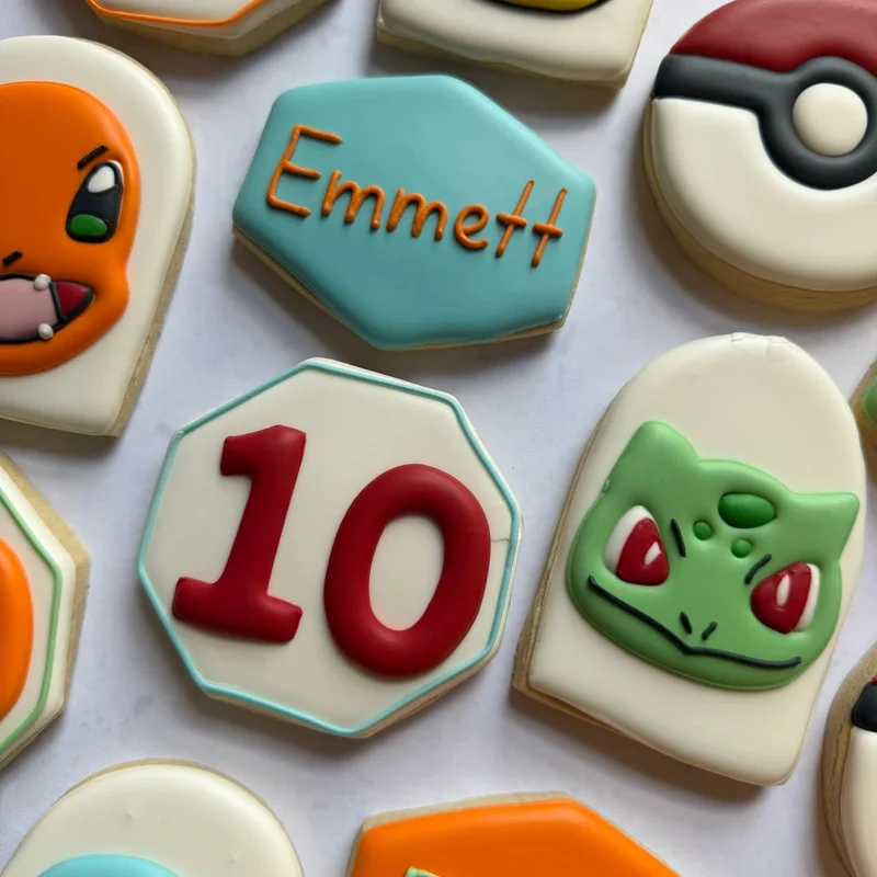Cartoon creature and poke ball cookies with the number ten.