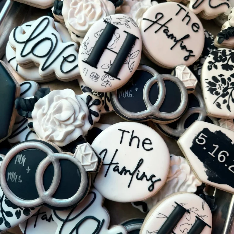 Black and white monogram, ring, and date cookies for a wedding.