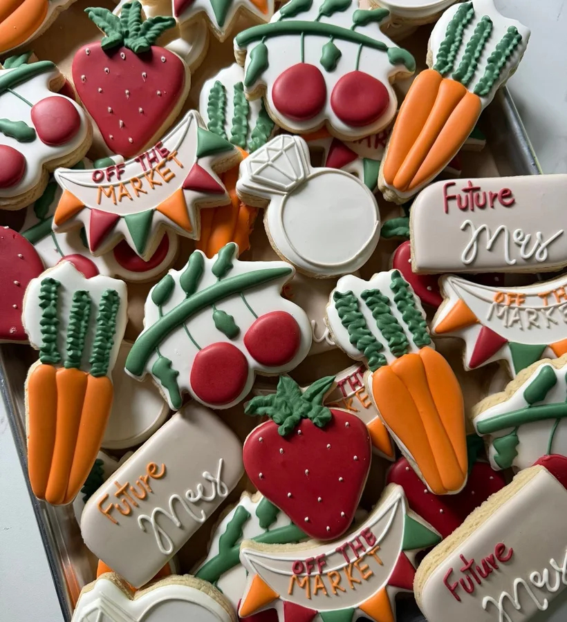 A farmers-market cookie spread with strawberries, carrots, and cherries.